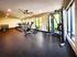 Shore Acres Apartments in Indianapolis, IN - Modern fitness center with state-of-the-art equipment, including treadmills, weight racks, and exercise bikes, surrounded by floor-to-ceiling windows offering scenic views.