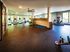 Shore Acres Apartments in Indianapolis, IN - Modern fitness center with state-of-the-art equipment, vibrant decor, and panoramic windows showcasing lush greenery.