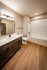 Shore Acres Apartments in Indianapolis, IN - Elegant bathroom with modern fixtures, large mirror, and a sleek bathtub set against chic white subway tiles.