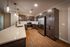 Shore Acres Apartments in Indianapolis, IN - Modern kitchen with sleek dark cabinetry, stainless steel appliances, and elegant pendant lighting over a spacious quartz countertop.