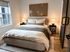 Luxury apartment bedroom at John Purdue Block in Lafayette, IN with a large window and black sliding barn door