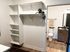 Contemporary walk-in closet with built-in shelving and an adjoining modern bathroom, complete with stylish fixtures and natural wood accents.