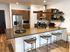 Modern kitchen with sleek appliances, stylish wooden cabinetry, and a spacious island with chic bar stools, perfect for entertaining.