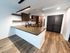 Modern kitchen with sleek countertops, stylish open shelving, and stainless steel appliances, illuminated by chic pendant lighting on elegant wooden flooring.