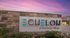Elegant entrance of Echelon at Monterrey Village with a modern stone wall and vibrant sunset backdrop.