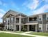 Stylish modern apartment building with stone accents and large windows, surrounded by lush green lawns under a blue sky.