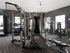 Modern gym with advanced workout equipment, including punching bag, weight machines, and elliptical trainers.