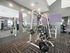 Modern fitness room with advanced weight lifting equipment and stylish interior design.