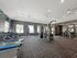 Spacious modern gym with treadmills, weight machines, and a punching bag in a well-lit room.