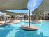 Relaxing outdoor pool with shaded seating areas, surrounded by modern apartments.