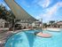 Stunning apartment pool area with modern shade sails and lush landscaping.