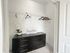 Spacious walk-in closet with black dresser, decorative orchid, and stylish hangers.
