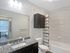 Bright and modern bathroom with granite countertop, sleek fixtures, and elegant shower curtain.