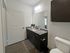 Contemporary bathroom featuring granite countertops, modern vanity, and bright lighting.