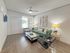 Bright and inviting living room with sleek, modern furniture, a plush teal sofa, and elegant decor.