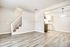 Chic modern apartment showcasing sleek wood flooring, a stylish staircase, and a cozy kitchen nook with elegant lighting.