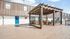 Charming outdoor space with wooden pergola and cozy seating, perfect for relaxation and gatherings, set against a modern apartment backdrop.
