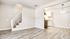 Contemporary open-plan apartment featuring elegant stairway, modern kitchen with stylish lighting, and sleek wood flooring.