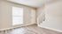 Bright, modern living area with elegant wood flooring and sleek staircase, perfect for a cozy ambiance.
