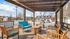 Charming outdoor patio with wooden seating under a stylish pergola, perfect for relaxation and community gatherings.