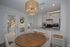 Charming dining area with round wooden table, modern kitchen with granite countertops, and inviting natural light from large patio doors.