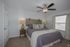 Cozy bedroom with plush bedding, stylish wooden headboard, and ambient lighting from elegant table lamps.