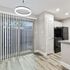 Modern kitchen with sleek cabinetry, pendant lighting, and floor-to-ceiling sliding glass doors opening to a serene outdoor view.