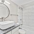 Modern bathroom featuring a sleek countertop sink, elegant tiled walls, and a luxurious bathtub.