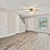 Bright and modern living room with elegant hardwood floors, ceiling fan, and large window for natural light.