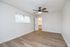 Bright and airy bedroom with sleek hardwood floors, a ceiling fan, and a spacious walk-in closet, perfect for modern living.