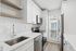 Modern kitchen with sleek stainless steel appliances, elegant white cabinetry, and abundant natural light.
