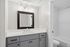 Modern bathroom with a sleek vanity, elegant mirror, and bright lighting, offering a refreshing atmosphere.