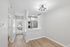 Modern open-concept apartment with sleek kitchen featuring stainless steel appliances, wood flooring, and contemporary lighting.