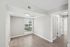 Bright and airy room with large window, modern light fixture, and elegant wood flooring, perfect for a cozy living space.