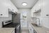 Modern kitchen with stainless steel appliances, elegant white cabinetry, and granite countertops.