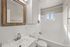 Charming bathroom featuring a modern marble countertop, elegant mirror, and bright natural light for a refreshing ambiance.