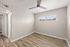 Bright bedroom with elegant hardwood flooring, large window for natural light, and a modern ceiling fan.