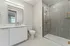 Berkeley, CO, Apartments Near Panorama Park - The Irwin - Spa Inspired Bathroom With White Vanity, Quartz Countertop, Brass Fixtures, Framed Mirror, And Glass Shower With Textured Tile.