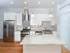 Elegant kitchen with white cabinetry, stainless steel appliances, and a large center island.