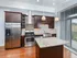 Contemporary kitchen featuring stainless steel appliances, elegant dark wood cabinetry, and a spacious island countertop.