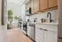 Chic apartment kitchen featuring elegant cabinetry, modern appliances, and a cozy dining nook with abundant natural light.