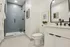 Elegant modern bathroom with sleek black fixtures, glass-enclosed shower, and stylish decor accents.