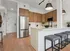 Modern kitchen with sleek stainless steel appliances, elegant pendant lighting, and a stylish breakfast bar with cozy stools.