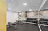 Modern fitness room with sleek benches, vibrant abstract mural, and a full set of dumbbells.