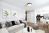 Chic modern living room with cozy gray sofa, vibrant botanical art, and sleek open kitchen in elegant white design.