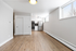 Bright and modern apartment space featuring sleek hardwood floors, large windows, and a stylish kitchen with stainless steel appliances.