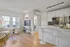 Bright modern apartment featuring a cozy living room with large windows, sleek kitchen with stainless steel appliances, and elegant dining area with barstools.