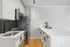 Sleek modern kitchen with stainless steel appliances, elegant black fixtures, and a spacious white countertop island.