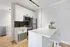 Chic modern kitchen with sleek white cabinetry, stainless steel appliances, and a stylish breakfast bar enhanced by elegant decor.