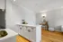 Bright, modern kitchen with sleek white cabinetry, cozy seating area with a stylish vanity, creating a chic and inviting living space.